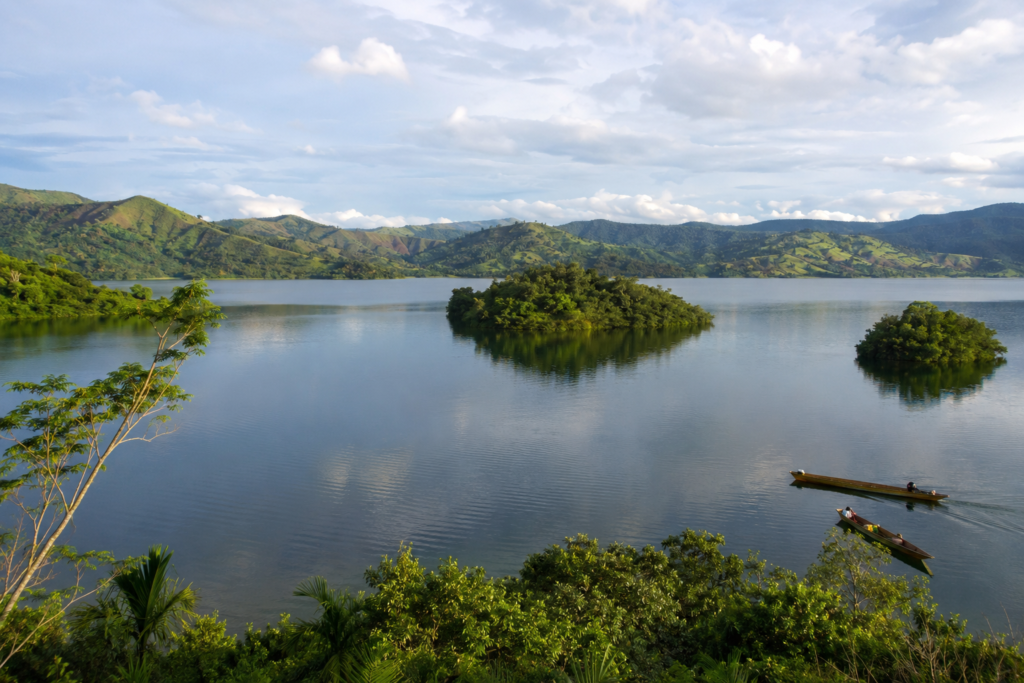 Pemandangan Danau Sentani Papua dengan perahu kecil, perbukitan hijau, dan suasana alam yang tenang